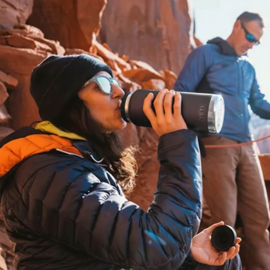 Frau trinkt aus Camping Becher