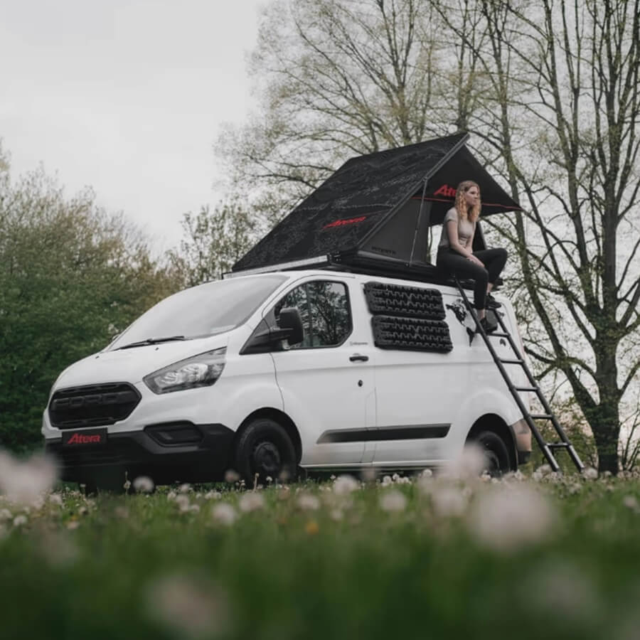 Frau sitzt in Dachzelt