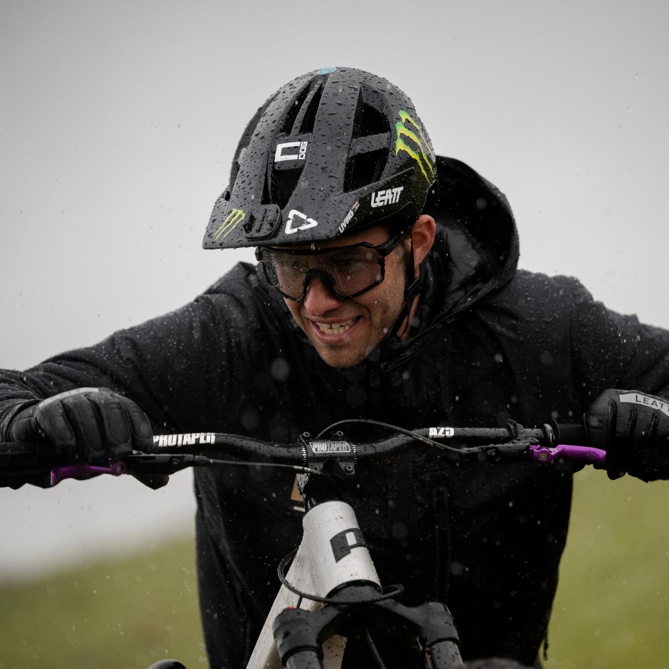 Mann im Regen mit Fahrradhelm