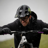 Mann im Regen mit Fahrradhelm