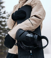 Snowboard mit Bindung für Damen unterm Arm