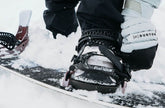 Frau steckt Schuh in Snowboard Bindung für Damen
