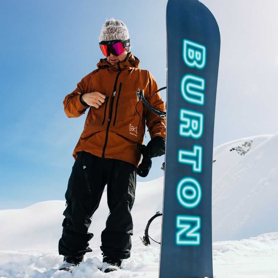 Mann neben Snowboard aus Powstore Shop