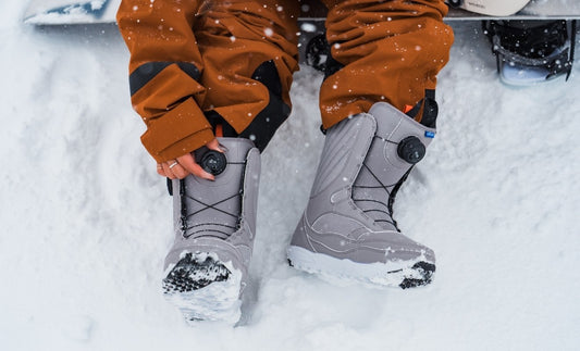Person zeigt Snowboard Boots Größe