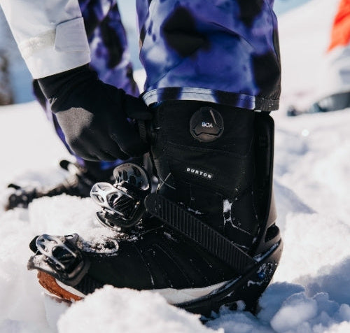 Snowboards Boots für Kids werden angezogen