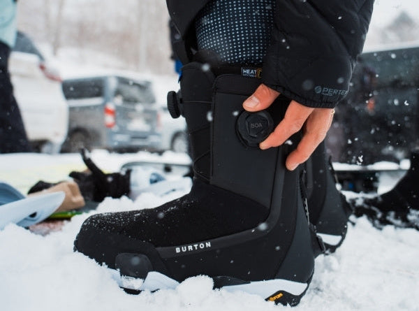 Snowboards Boots werden im Schnee eingestellt