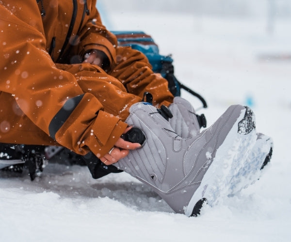 Snowboard Boots Damen werden im Schnee eingestellt