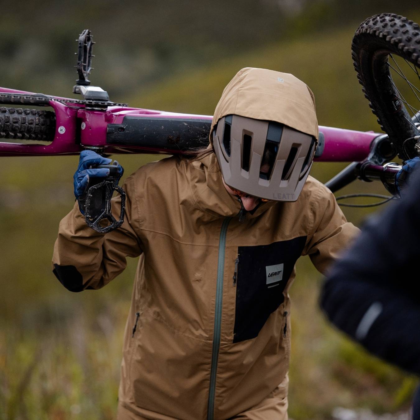 Frau mit Fahrradjacke trägt Fahrrad