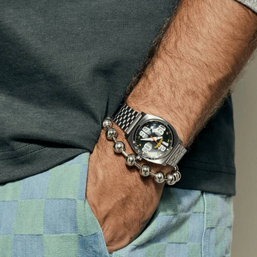 Mann hat Nixon Uhr am Handgelenk