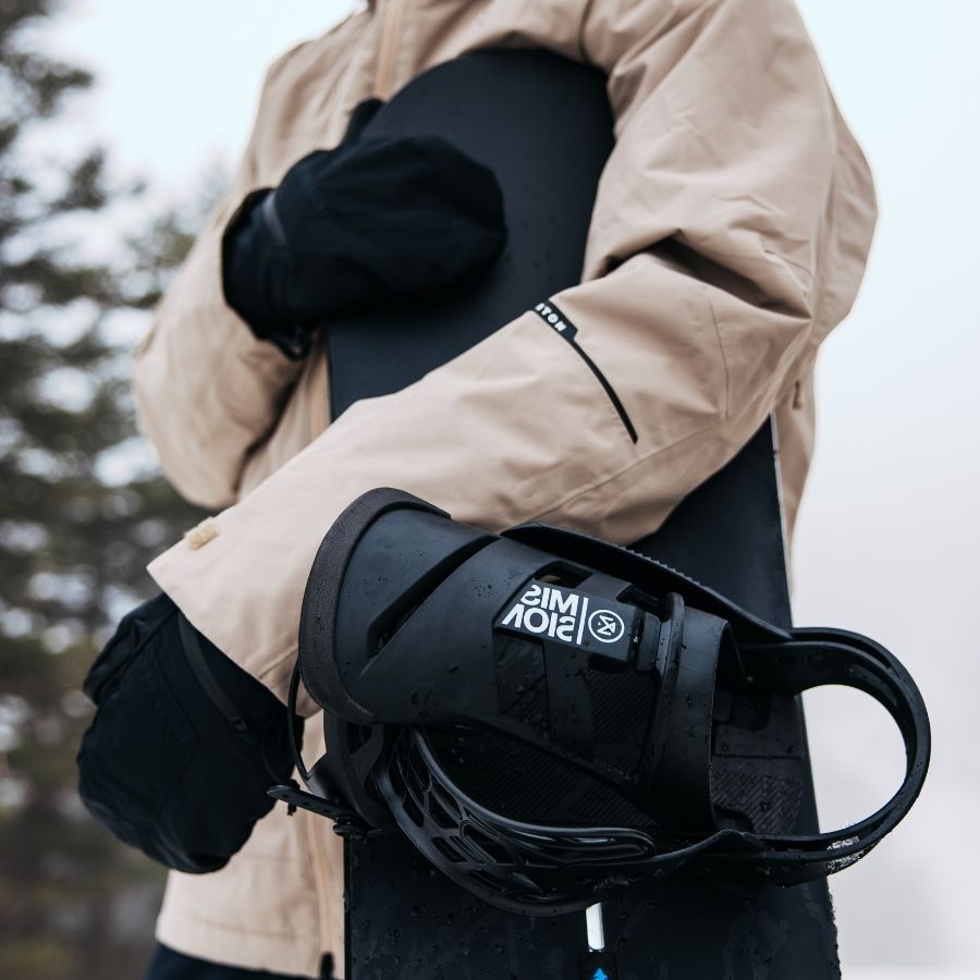 Person hält Snowboard mit Bindung