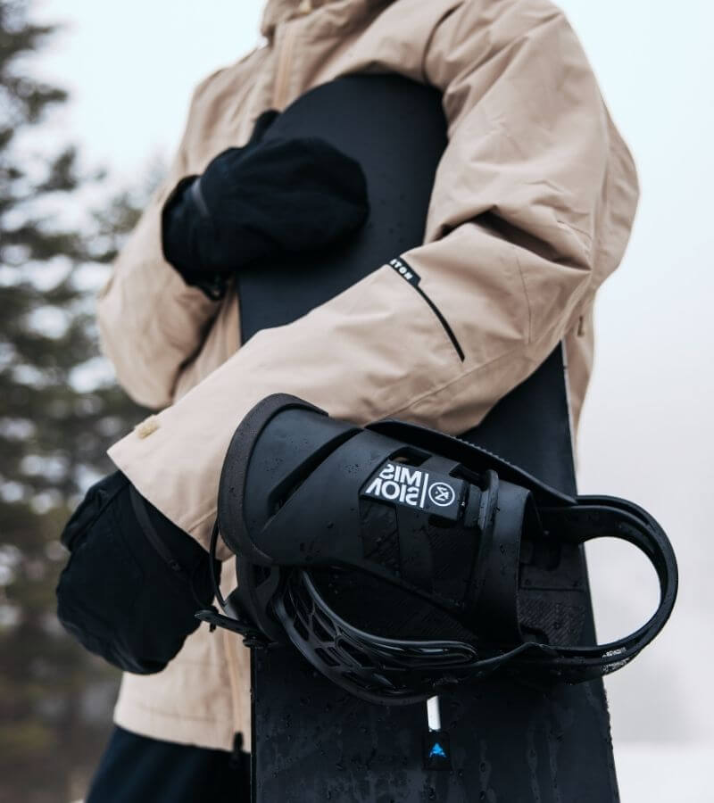 Snowboard mit Bindung für Damen unterm Arm