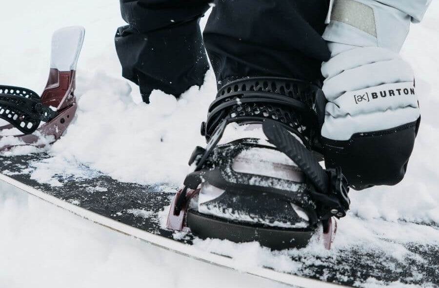Frau steckt Schuh in Snowboard Bindung für Damen