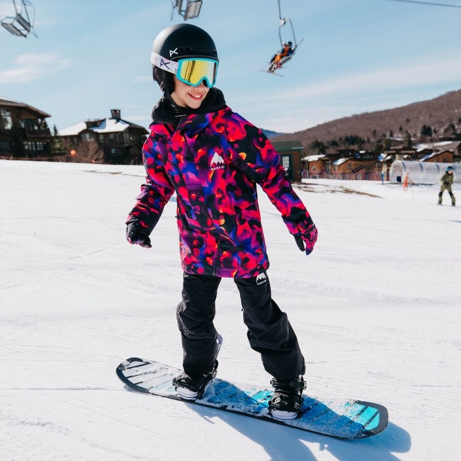 Kind auf Snowboard mit Bindungen für Kinder auf Piste