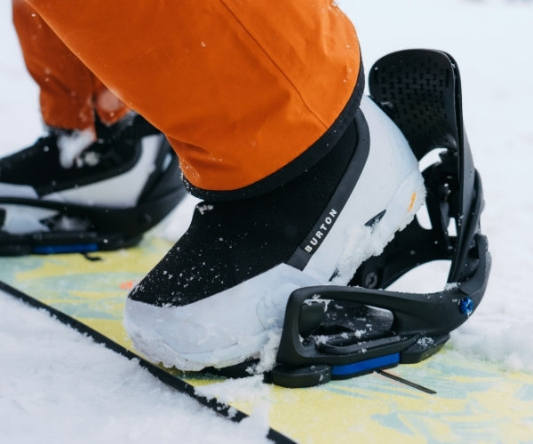 Step On Boots auf einem Snowboard im Schnee